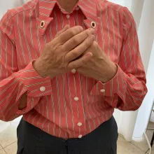 Dies ist eine maßgeschneiderte Bluse in einem sportlichen Schnitt. Sie hat einen zarten lachston mit weißen Streifen und geknöpft wird sie mit weißen Perlmutknöpfen. Die Manschetten sind in Pfeilform zugeschnitten passend zum Kragen.