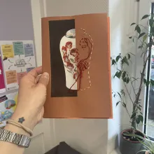 Person arbeitet an einem handgemachten Kunstbuch aus Papier und Schnuren