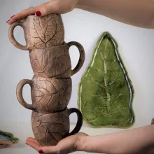 Handgefertigte Keramiktassen und Teller mit pflanzlichen Abdrücken