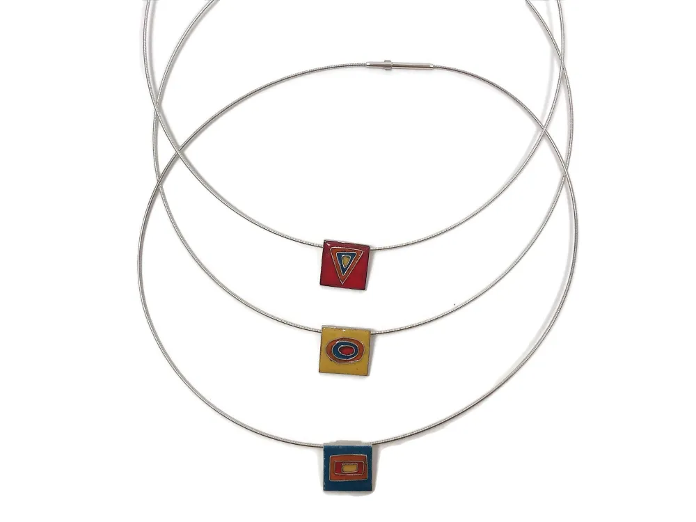 Kettenanhänger aus Emaille und Silber mit geometrischen Formen als Motiv.