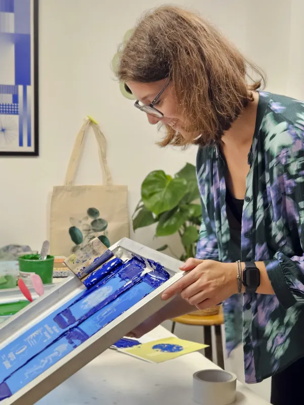 Person druckt mit einem Siebdruckrahmen