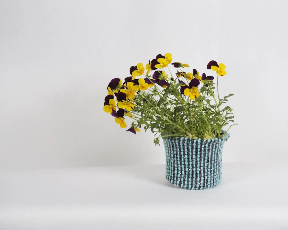 Blumentopfmanschette aus Videoband und Wolle