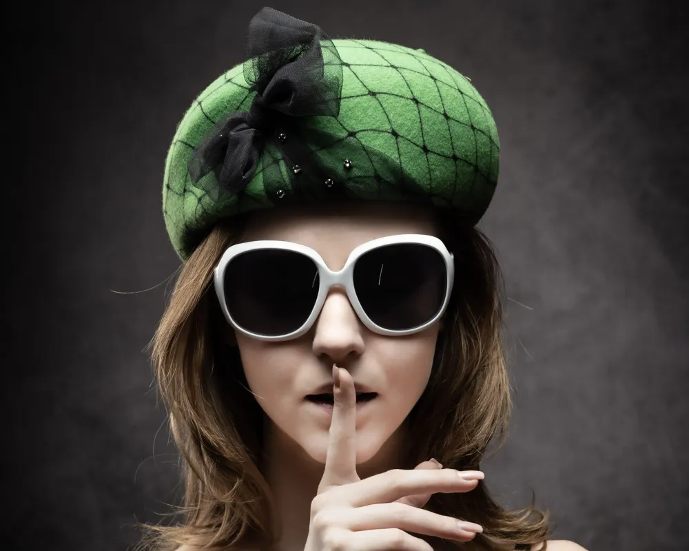 Frau mit grünem Béret und Sonnenbrille