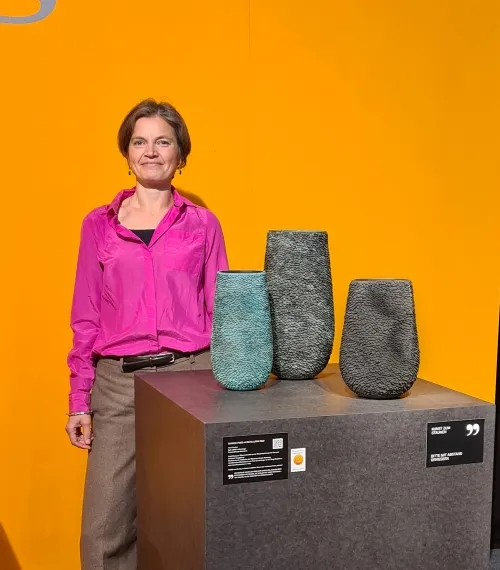 Anne Fischer neben ihren drei Gefäßen aus Bronze- ausgezeichnet mit dem Bayerischen Staatspreis 2025