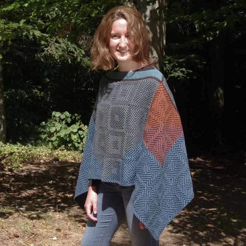 Model in Poncho im grafischen "Chiaras Squares" StrickStrandDesign mit starkem Licht- & schatteneffekt
