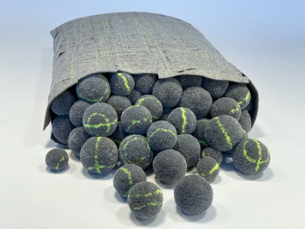 Pompon Kissen mit herausquillenden Wollpompons mit neonfarbenem Akzet