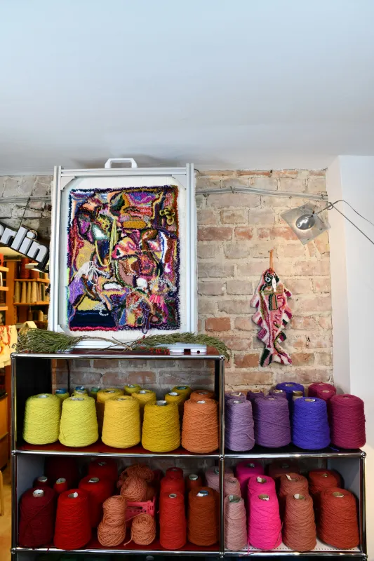 Ein getuftetes Kunstwerk mit farbenfroher Wolle darunter.