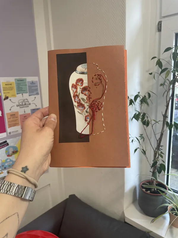 Person arbeitet an einem handgemachten Kunstbuch aus Papier und Schnuren