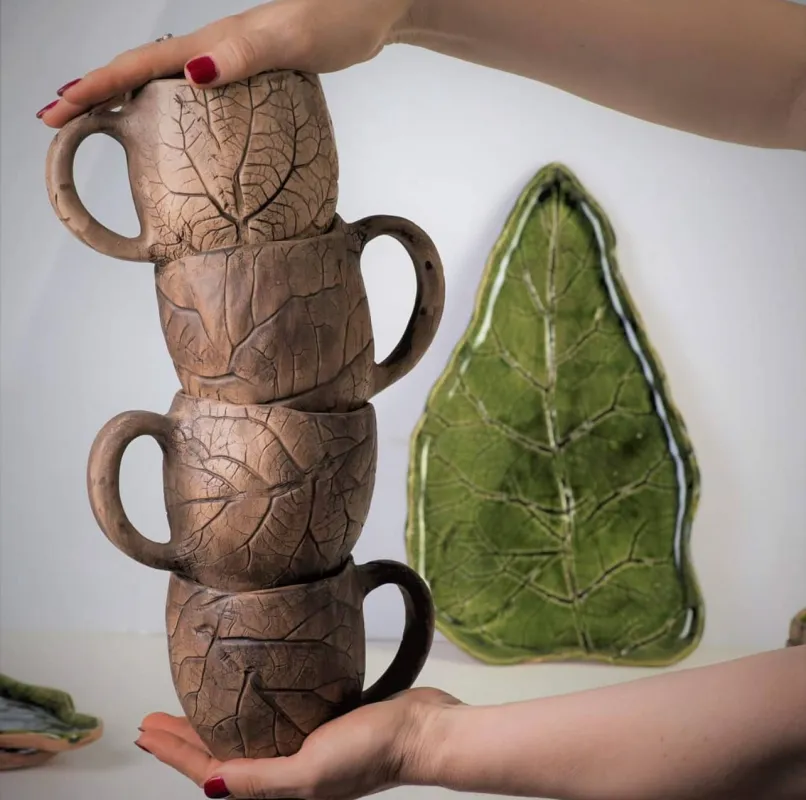 Handgefertigte Keramiktassen und Teller mit pflanzlichen Abdrücken