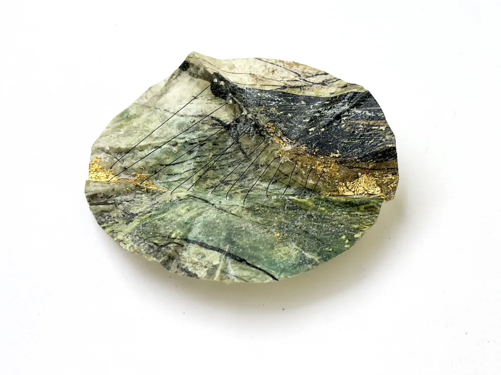 Ein rundes Objekt aus farbig gestaltetem Papier, das an eine Landschaft von oben erinnert.