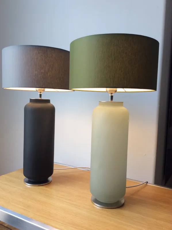 Zylindrische Vasenlampen in grün und schwarz.