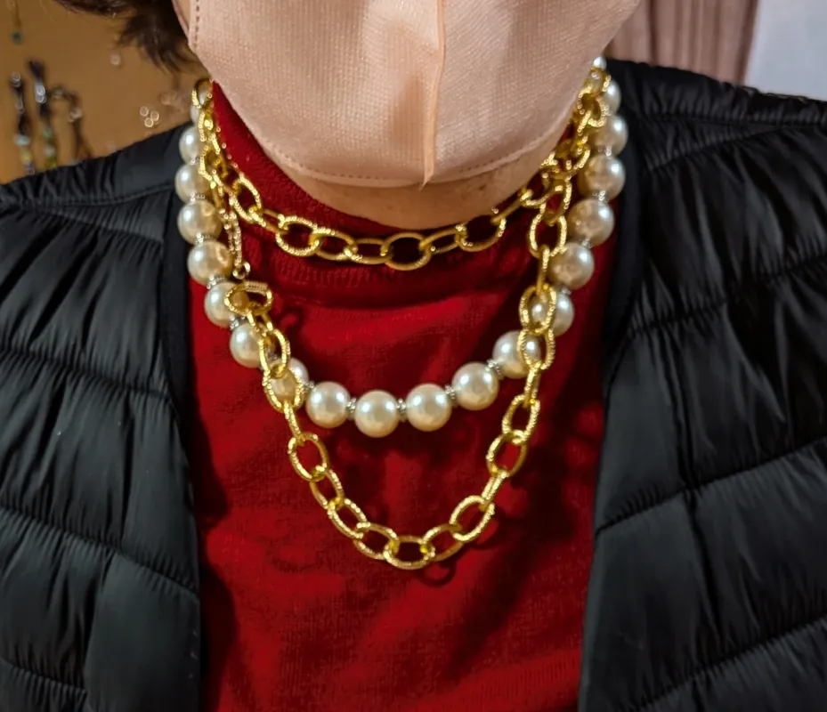 Handmade necklace featuring pearl beads and other handcrafted elements.