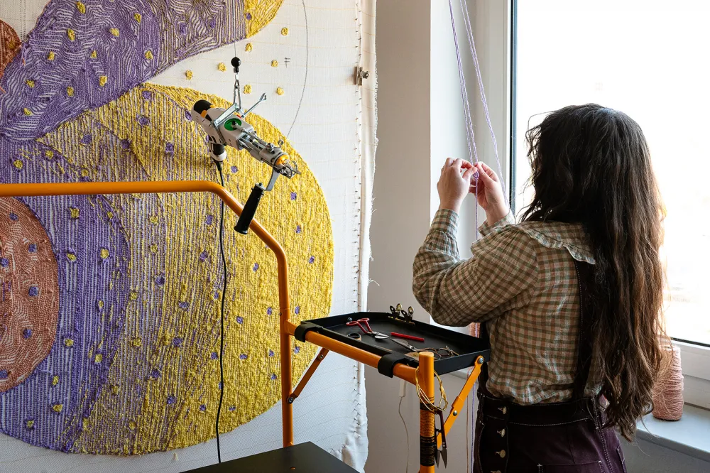 Designerin Viviana Losacco bei der Arbeit am Tuftingrahmen