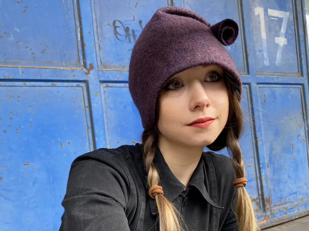 Ulli Meins/Sönke Meins "WinterAmy" - Kappe aus gekochter Wolle in einer Beerenfarbe, mit angelegtem Zipfelchen - in einem frei tänzelndem Tütchen endend.