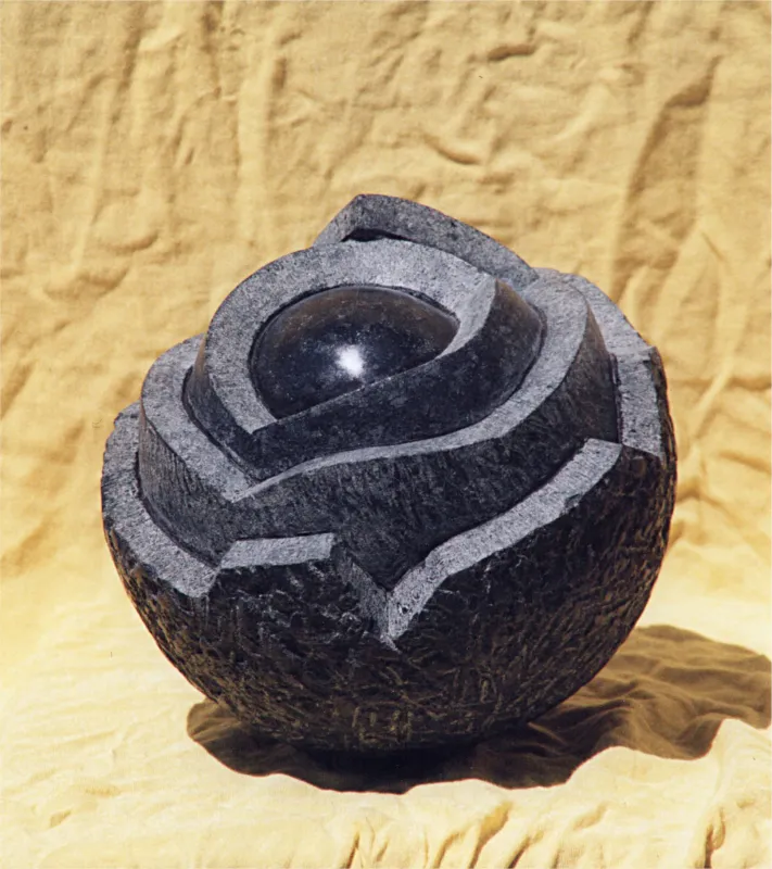 Kugelskulptur aus antrahzitfarbigem Stein.